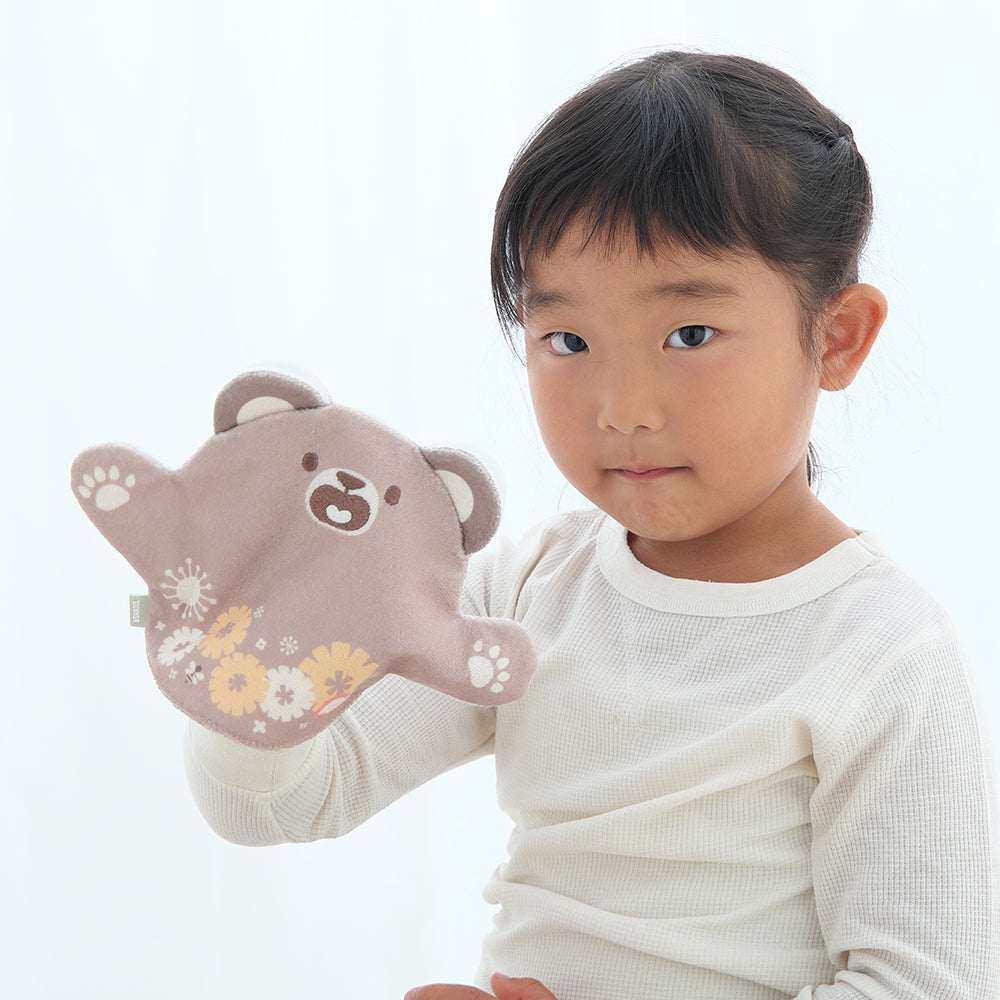 右手にいないいないばぁスタイくまをつけた女の子