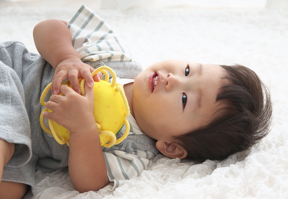 わっかボールグレープフルーツを抱える赤ちゃん