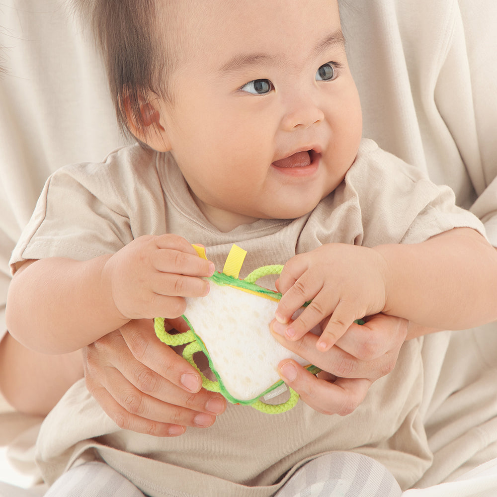 わっかラトルサンドイッチを持つ赤ちゃん