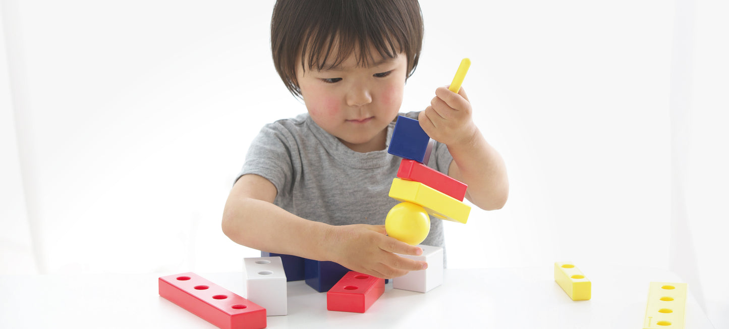 コロンブスのつみきバランスセットのつみきを紐通しに通す子供