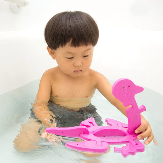 組み立てたフローティックぺんぎん/くびながりゅうを使ってお風呂で遊ぶ子供