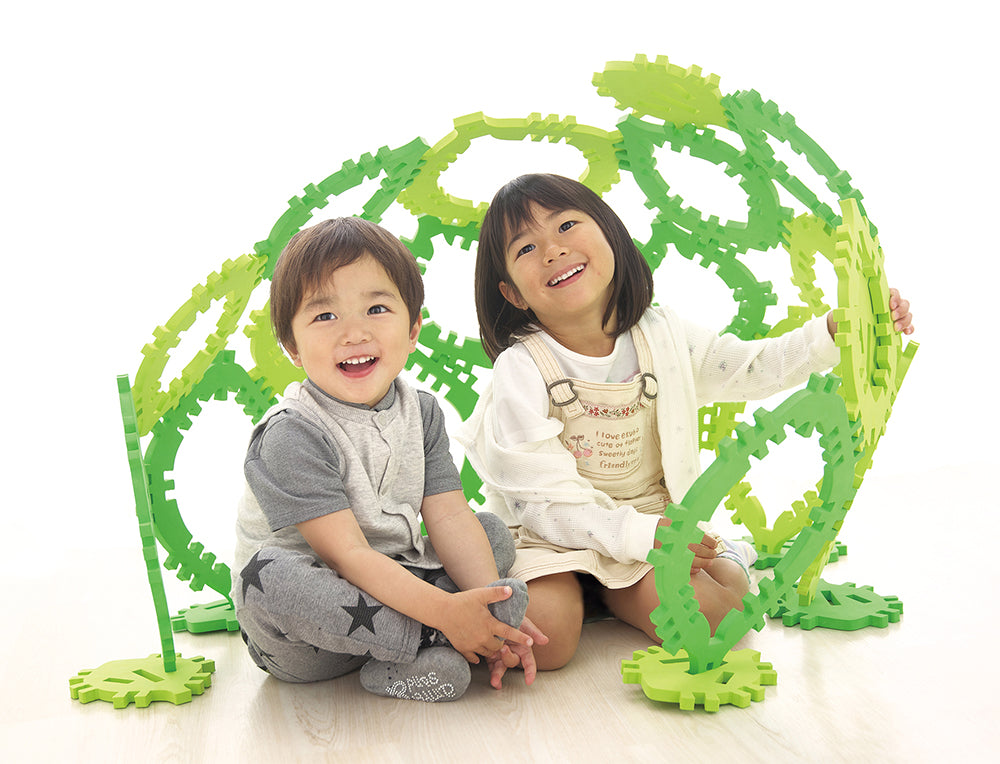 組み立てたクムタス葉っぱのおうちセットで遊ぶ2人の子供
