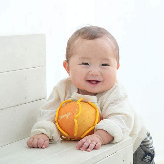 わっかボールみかんを笑顔で抱える赤ちゃん